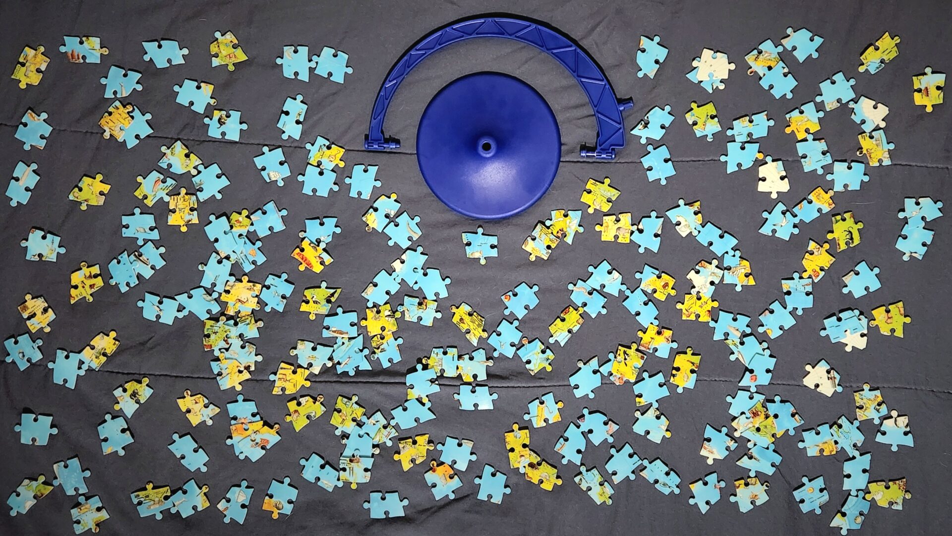 Completely unassembled puzzle globe pieces scattered on a bed.